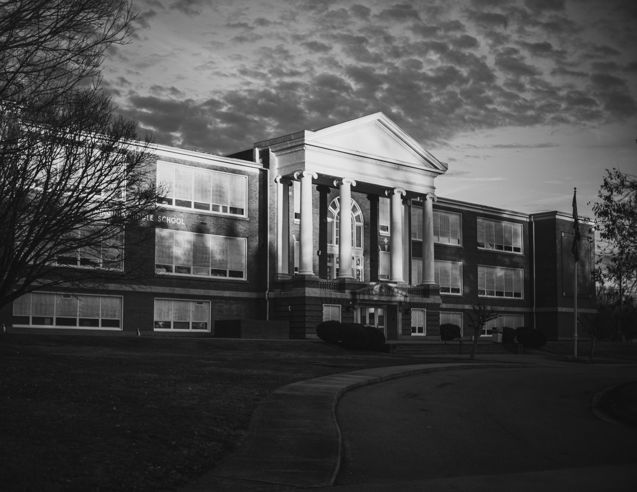 Illustrative black-and-white exterior photograph of a school building; not a Jackie Project client site