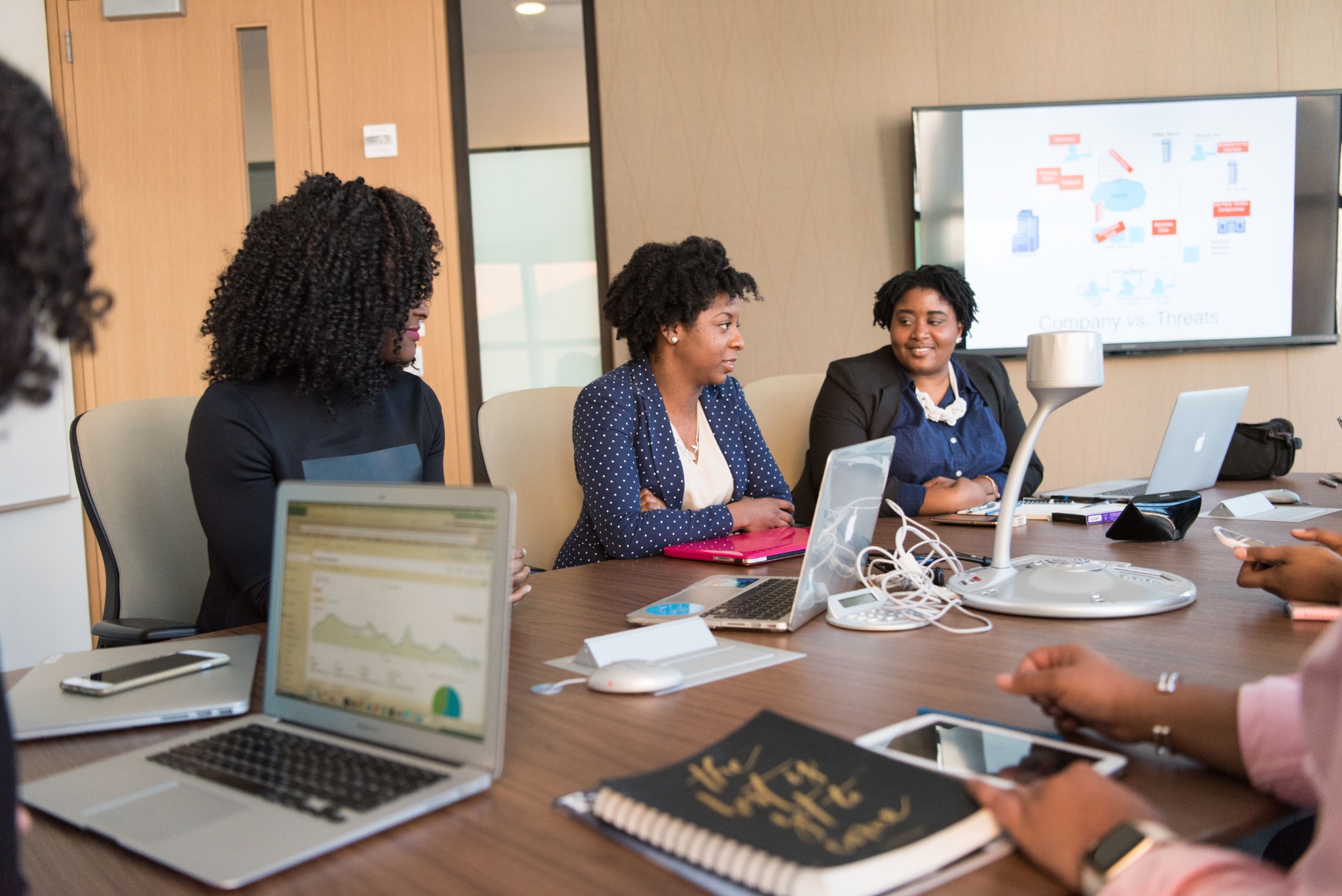 Professionals in conversation around a table, illustrating collaborative culture work
