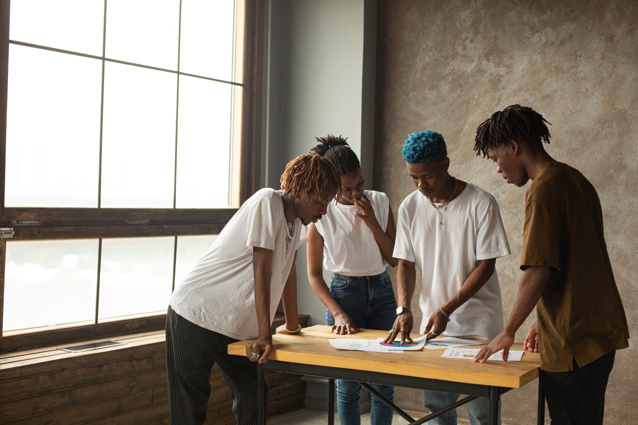Black professionals reviewing project documents together around a table